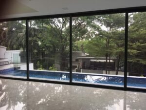 Front view of a luxurious 5-storey bungalow in Bukit Tunku, featuring modern architectural design, a private swimming pool with city views, and surrounded by lush greenery