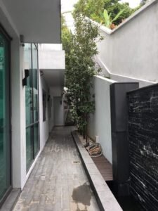 Front view of a luxurious 5-storey bungalow in Bukit Tunku, featuring modern architectural design, a private swimming pool with city views, and surrounded by lush greenery