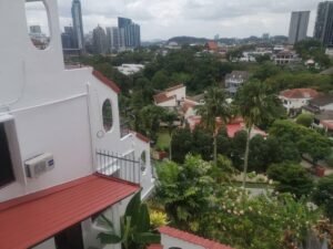 Front view of a luxurious 3-storey bungalow in Jelutong Villas, Damansara Heights, featuring modern architectural design and a beautifully landscaped garden."